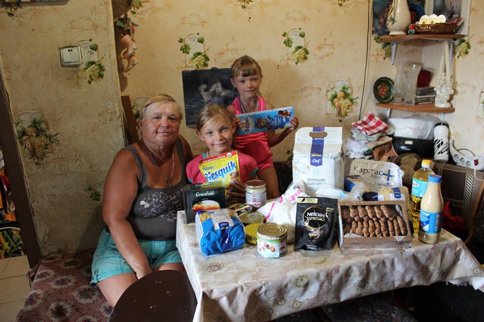 rodina za plným stolom darovaných potravín. Aj tak žijú rodiny na východe Ukrajiny.
