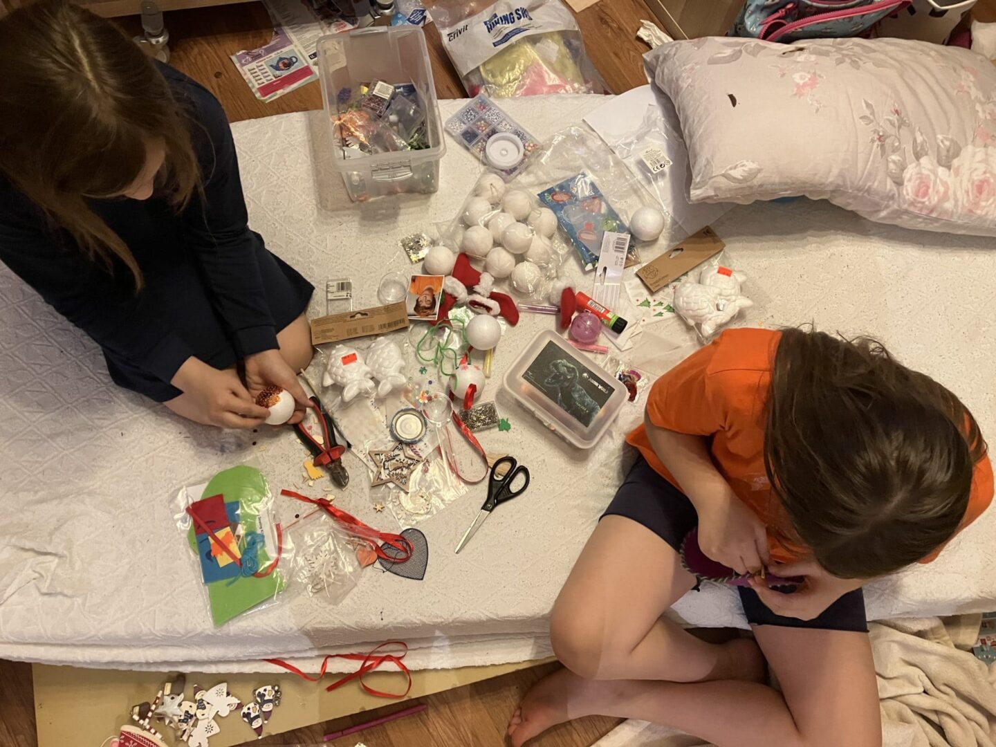 Dve dievčatá sedia medzi vecami na vyrábanie
