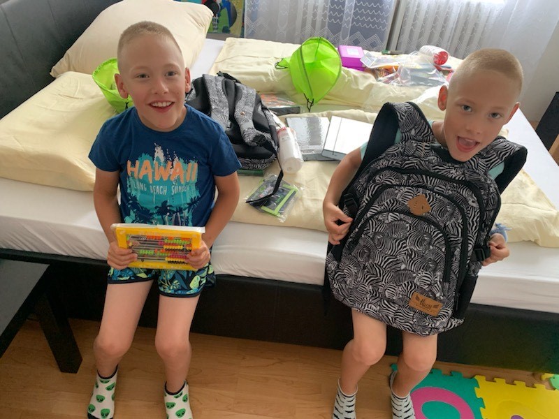 Dvaja chlapci s úsmevom držia nové školské pomôcky