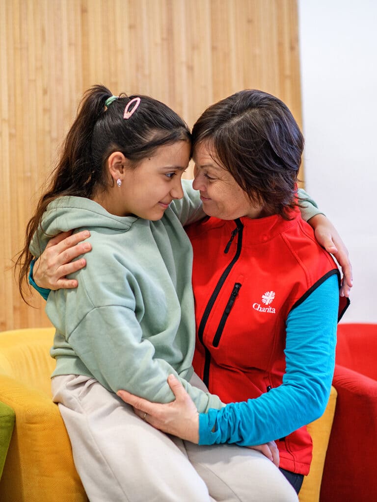 pracovníčka charity objíma dievča