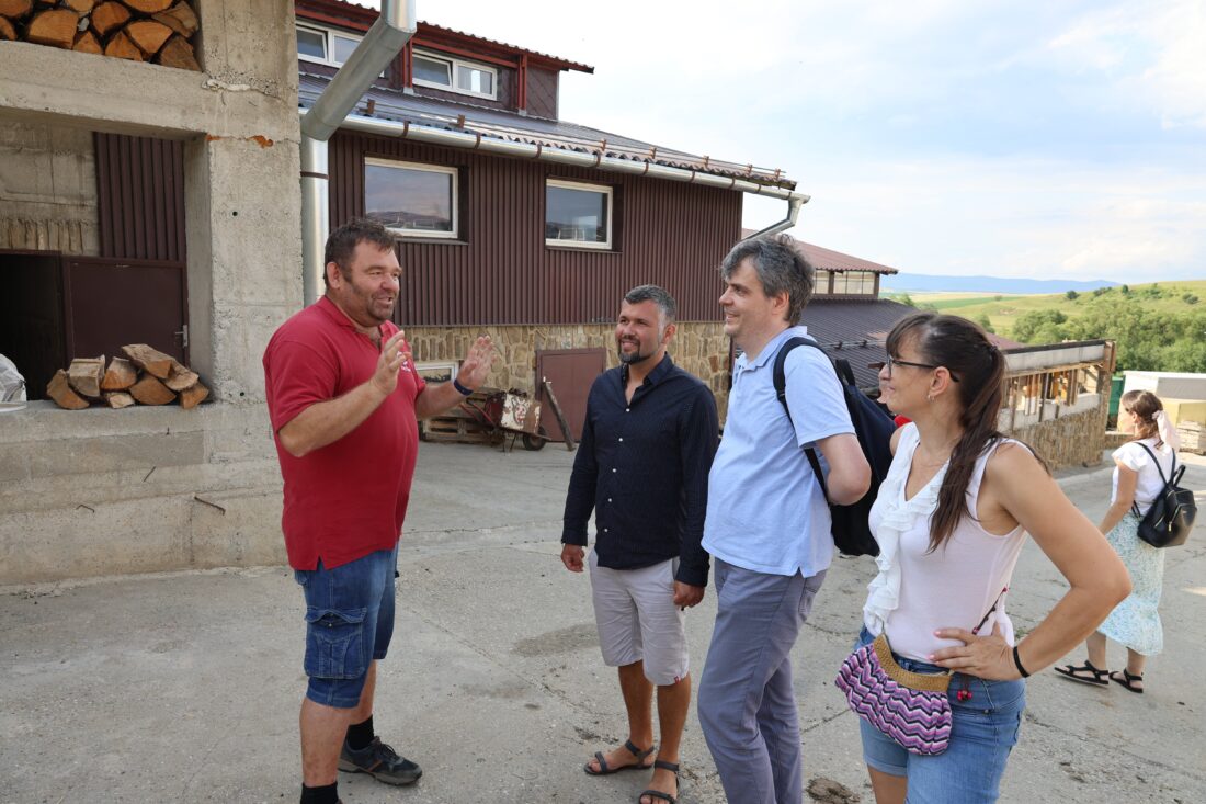 Tri muži a jedna žena sa rozprávajú počas návštevy Inštitútu Krista Veľkňaza