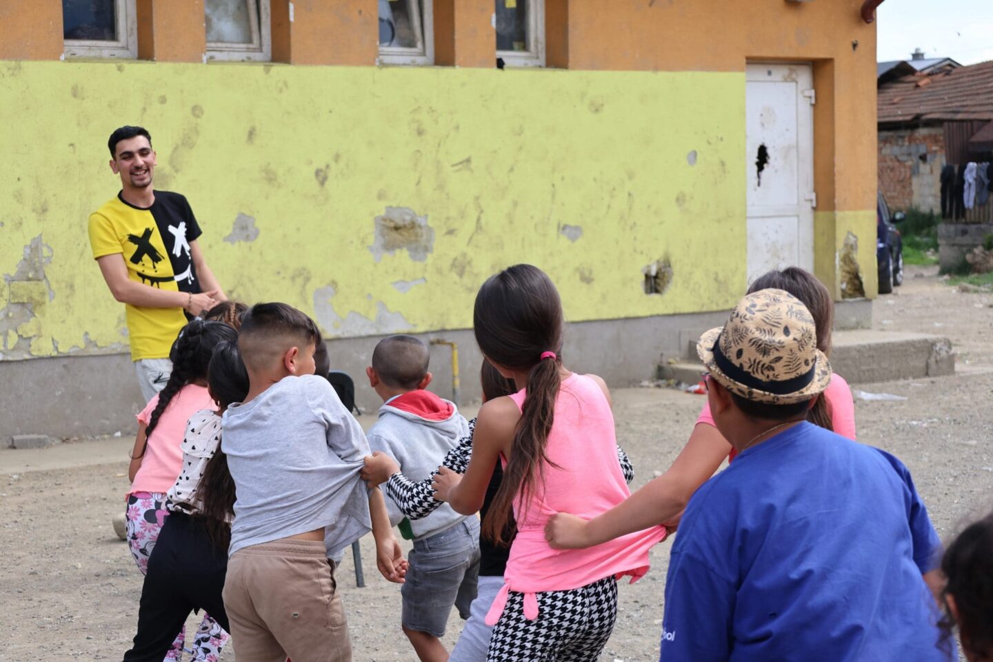 Muž sa hrá s deťmi a preťahuje sa na ihrisku