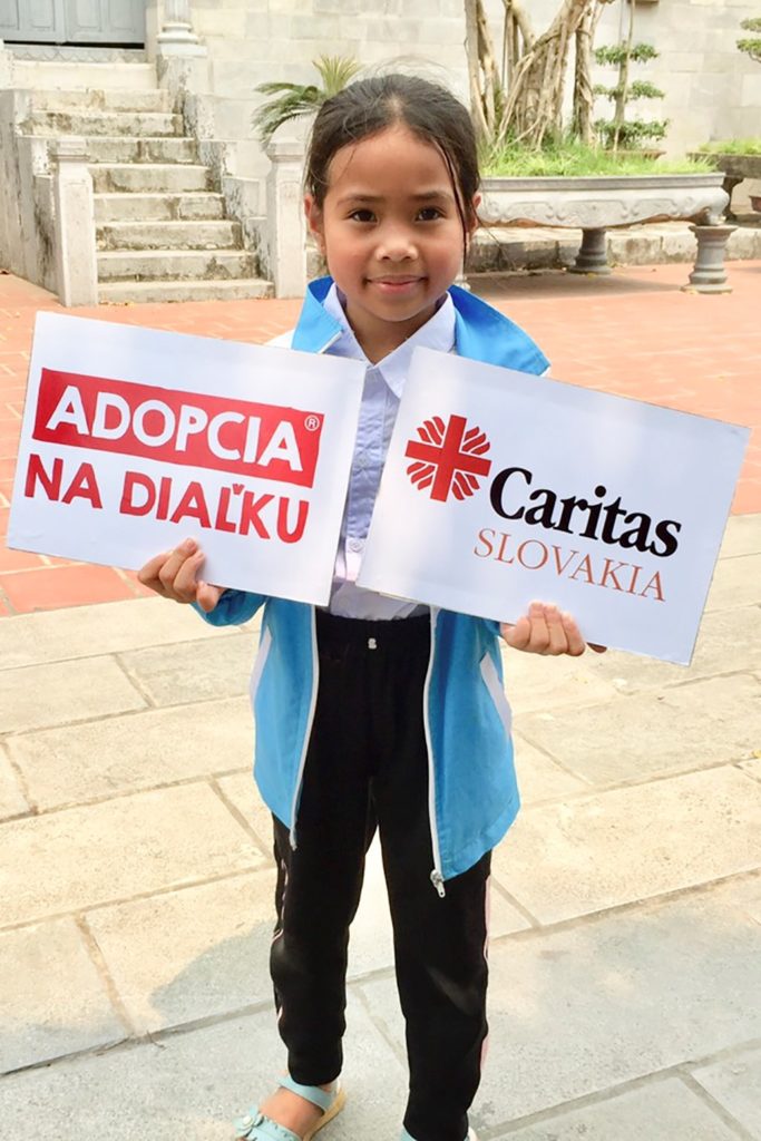 Vietnamské dievčatko so znakom Charitas Slovakia a nápisom Adopcia na diaľku