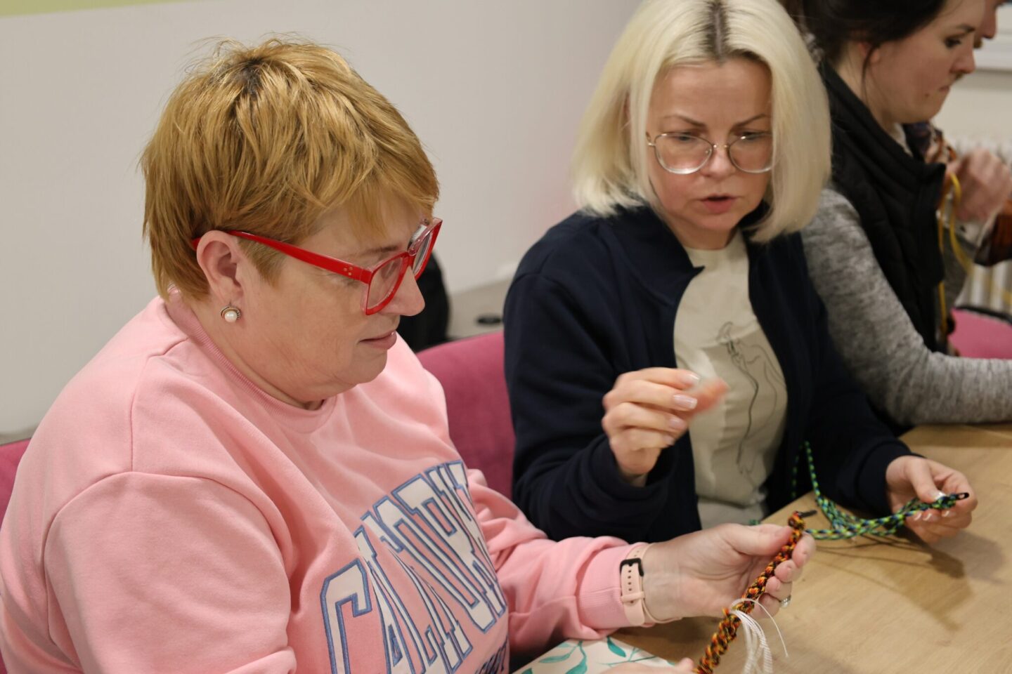 dve ženy vyrábajú náramky